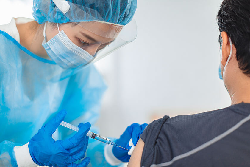 The doctor or nurse wears gowns, masks, and eye masks to help a patient in the injection