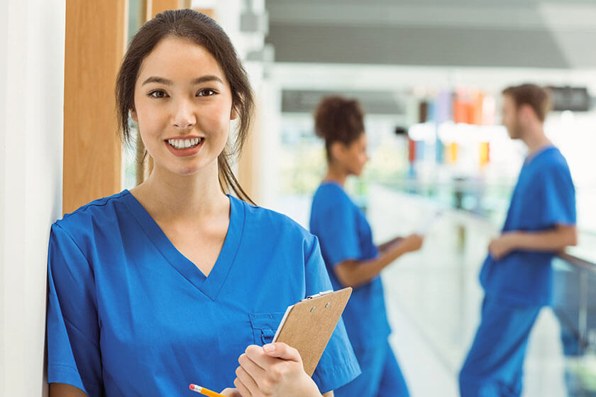 Medical student smiling at camera in hallway, phlebotomy certifications