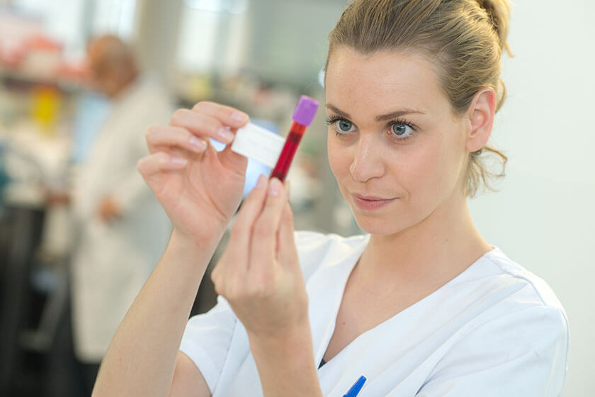 Nurse labeling blood in a vacuum tube