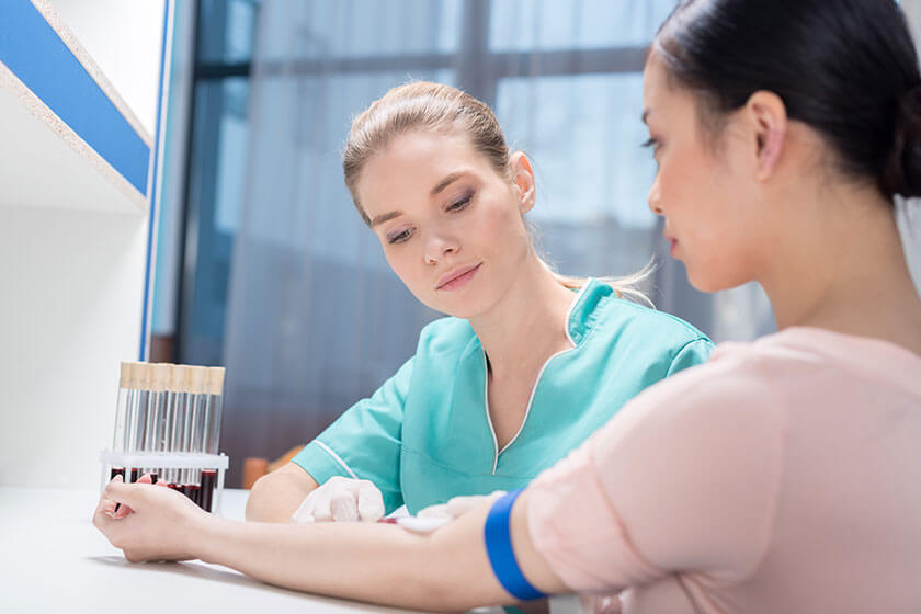 Nurse taking blood sample from patient