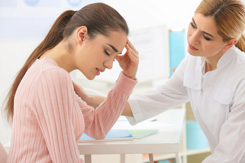 Depressed woman at doctors office, fainting during a blood draw